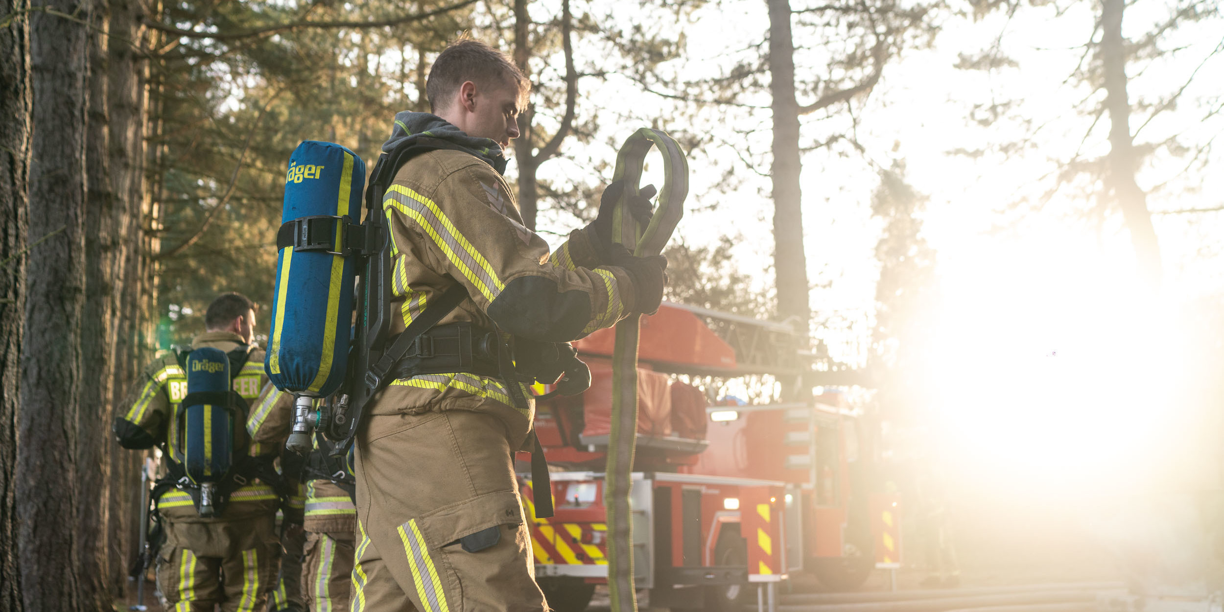 Brandweerman rolt slang op Brandweerman rolt slang op